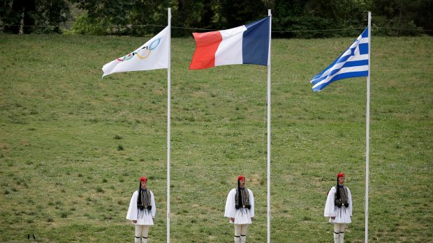 Čestná stráž příslušníků prezidentské gardy u olympijské, francouzské a řecké vlajky