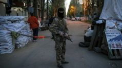 Proruský ozbrojenec hlídkuje u barikády nedaleko sídla bývalé tajné služby  ve Slavjansku