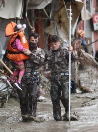 Záchranná jednotka po prohledávání zničených domů ve městě Bozkurt evakuuje dítě.
