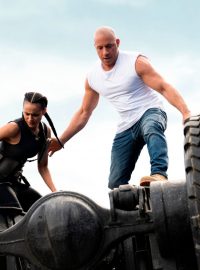 Nathalie Emmanuel a Vin Diesel balancují na spodku obrněného kolosu ve snímku Rychle a zběsile 9